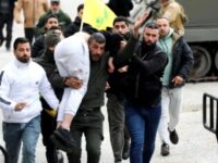 Seorang pria menggendong korban luka di Burj al-Muluk, dekat desa Kfar Kila di Lebanon Selatan, tempat pasukan Israel masih berada di darat setelah batas waktu penarikan pasukan mereka berakhir karena penduduk berusaha kembali ke rumah mereka di daerah perbatasan, Lebanon. © Reuters