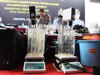 Petugas menyiapkan barang bukti sebelum berlangsungnya rilis pengungkapan kasus laboratorium terselubung narkotika jenis MDMB-4en-PINACA atau ganja sintesis di Polda Metro Jaya. Foto (Antara).