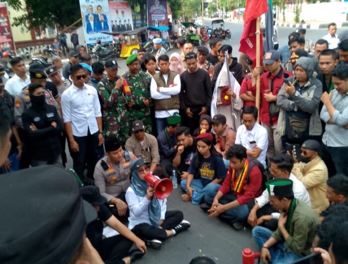 Bupati Gowa, Husniah Talenrang, mengambil langkah tak biasa: duduk bersila di atas aspal, tepat di tengah kerumunan demonstran.